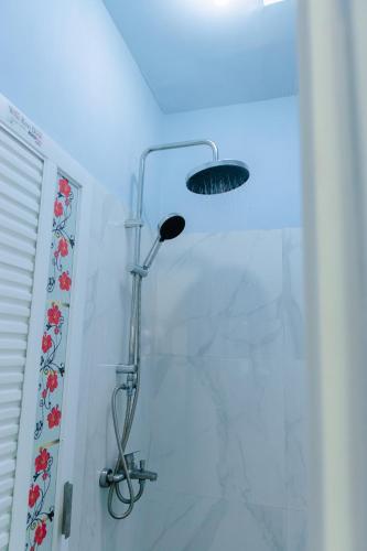 a shower with a shower head in a bathroom at Luchis HOME Ijen in Banyuwangi