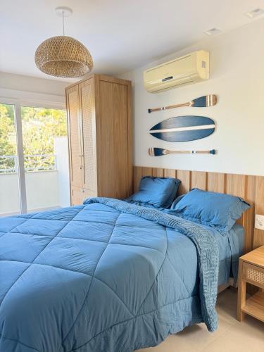 a bedroom with a blue bed and a fan at Casa GERIBÁ in Búzios