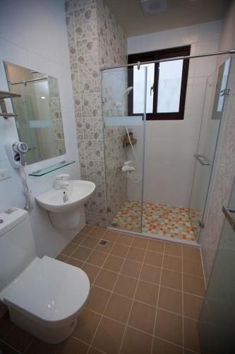 a bathroom with a shower and a toilet and a sink at Mallorca B&B in Taitung City