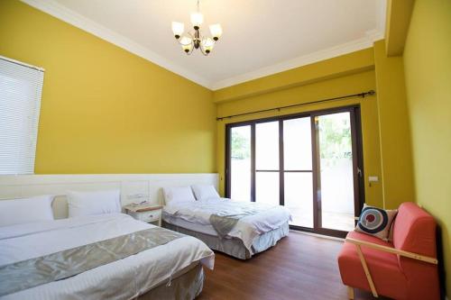 a hotel room with two beds and a window at Mallorca B&B in Taitung City