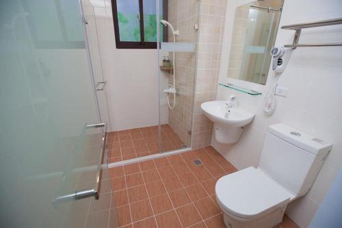 a bathroom with a shower and a toilet and a sink at Mallorca B&B in Taitung City