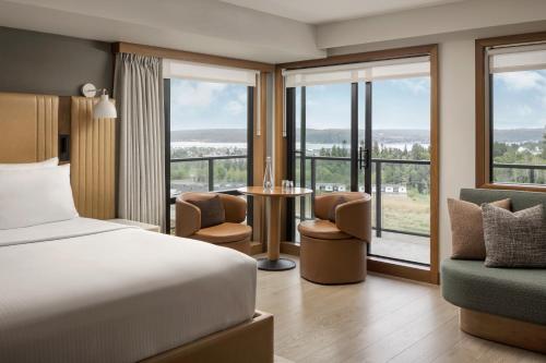 a hotel room with a bed and a large window at Naturally Pacific Resort in Campbell River