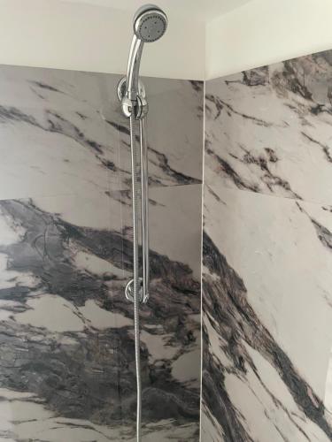 a shower in a bathroom with a marble wall at Cabernet Sauvignon Escape in Calgary