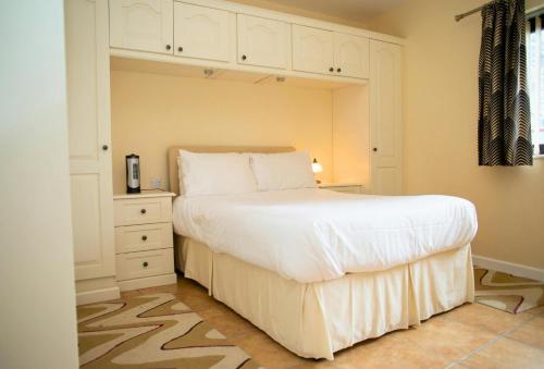 a bedroom with a large white bed and a dresser at Ger Y Llanw Aberaeron in Aberaeron