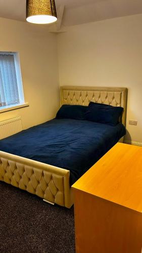 a bedroom with a large bed with a wooden table at HomesRentals in Dudley