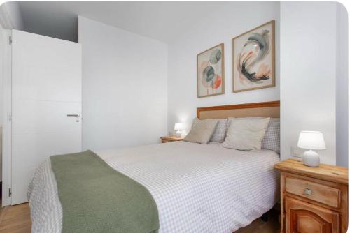 ein Schlafzimmer mit einem Bett und zwei Gemälden an der Wand in der Unterkunft Estudio Key in Icod de los Vinos