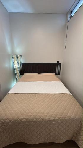 a large bed in a room with a window at 2Studio no centro, aconchegante no coração da cidade, UFLA - UNILAVRAS in Lavras