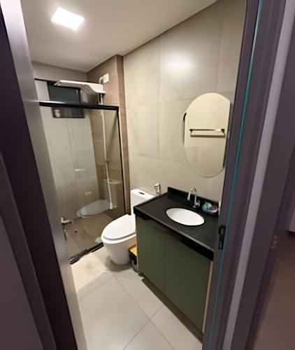 a bathroom with a toilet and a sink and a mirror at Flat 2/4 - Prestige 204 - Praia do Francês in Marechal Deodoro