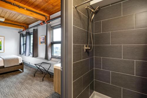 a bathroom with a shower stall and a tub at Seward Adventure Lodge in Seward