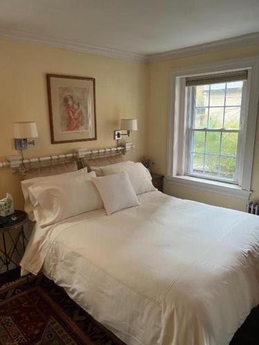 a white bed in a bedroom with a window at Riverview Organic Bed & Breakfast and Wellness Center in Piermont
