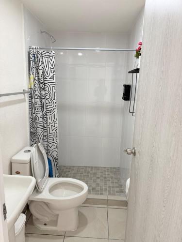 a white bathroom with a toilet and a shower at Bello departamento iluminado ideal para descansar in Querétaro