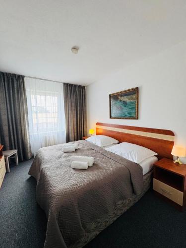 a hotel room with a large bed with two towels on it at Park Pension in Nové Benátky