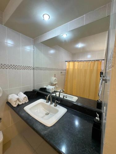a bathroom with a sink and a mirror at Luxurious Platinum House 3VX in San Pedro Sula