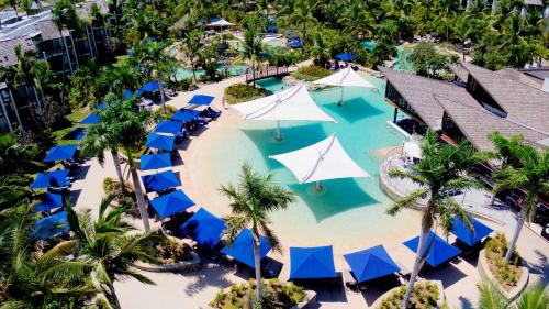 an aerial view of a resort pool with blue and white umbrellas at Radisson Blu Resort Fiji in Denarau