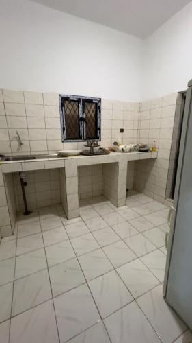 a bathroom with a sink and a tiled floor at Chez YaZ in Nouakchott