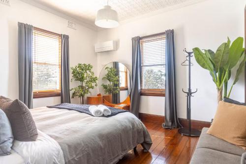 a bedroom with a bed and a mirror at William Arnott Boutique Accommodation in Morpeth