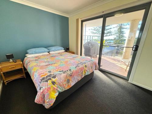 a bedroom with a bed and a balcony at Northpoint Apartment 5 - Bring your own linen. in South West Rocks