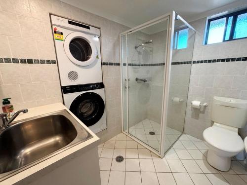 a bathroom with a sink and a washing machine at Northpoint Apartment 5 - Bring your own linen. in South West Rocks