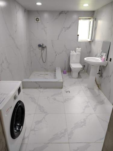 a white bathroom with a toilet and a sink at gulelebi in Tʼianetʼi