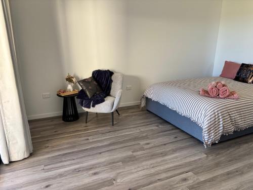 a bedroom with a bed and a chair at Hanger Ridge Cabin in Goodger