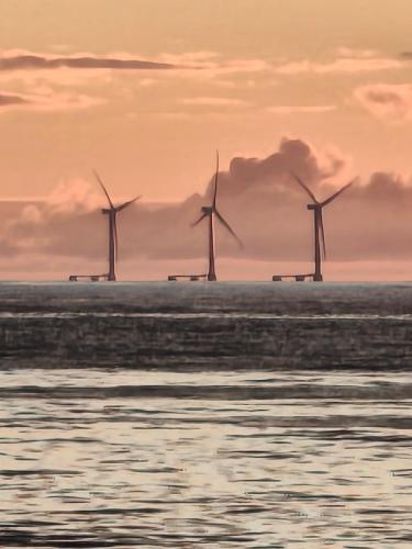 Eine Gruppe von Windmühlen im Meer bei Sonnenuntergang in der Unterkunft Alojamento lunar in Viana do Castelo