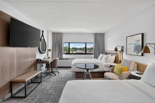 a hotel room with two beds and a couch at Crowne Plaza Lansing by IHG in Lansing