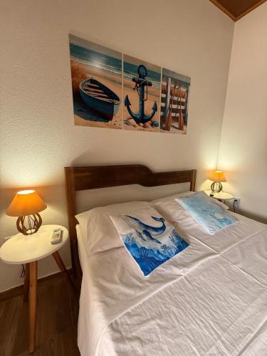 a bedroom with a white bed with a picture on the wall at Studio Praia do Chapéu in Mata de Sao Joao