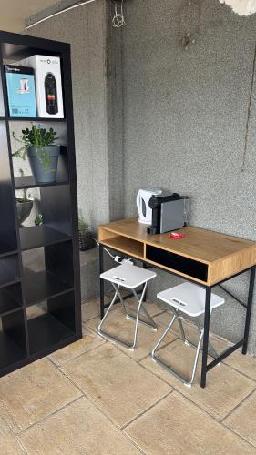 a wooden desk with two chairs next to a wall at Valença RoofTop by Beeflats BnB in Valença