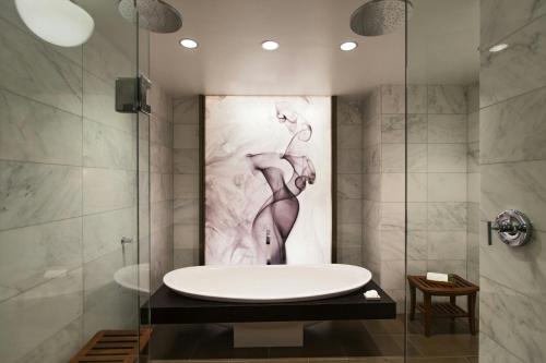 a bathroom with a tub and a painting of a woman at Renaissance Chicago Downtown Hotel in Chicago