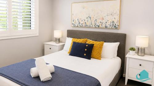 a bedroom with a large white bed with yellow and blue pillows at Castaway at Pelican in Pelican Flat