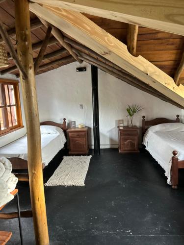 a attic room with two beds and wooden ceilings at La Cabaña de Caro in Mar de Cobo