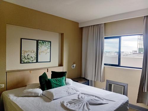 a hotel room with a bed with a large window at Ambassador Residence Apart-hotel in Curitiba