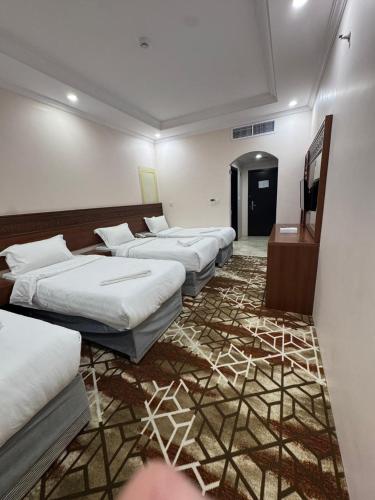a row of beds in a room with a carpet at فندق فيفيان الجميزة in An Naqāʼ