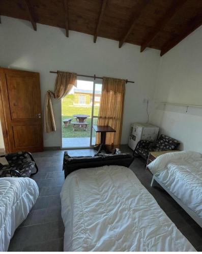 a bedroom with two beds and a table and a window at Posada La Martina in Goya