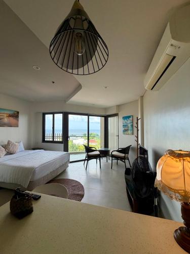 a bedroom with a bed and a room with a table at Room in Maribago in Lapu Lapu City