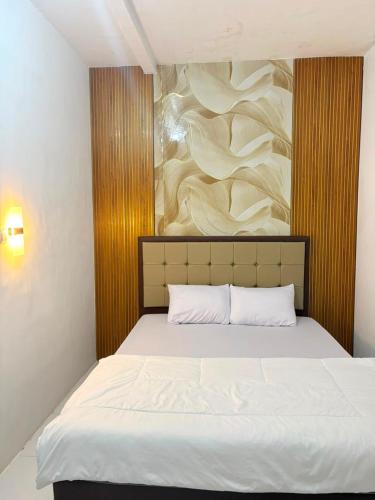 a bedroom with a bed with a painting on the wall at Homestay Anugerah Tumpak sewu in Lumajang