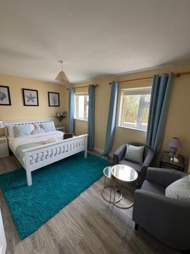 a bedroom with a bed and a couch and a table at Erris Ocean House in Belmullet