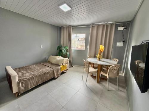 a bedroom with a bed and a table in it at Apto moderno no Centro Com Ar e Wi-Fi in Caruaru