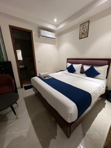 a bedroom with a large bed with blue pillows at Hotel Ivory Delhi Airport in New Delhi