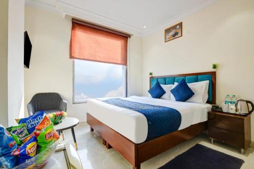 a bedroom with a bed and a chair and a window at Hotel Ivory Delhi Airport in New Delhi