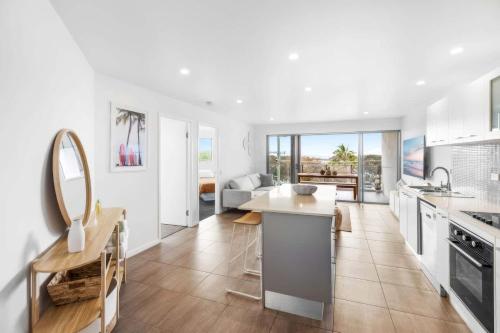 a kitchen with white cabinets and a counter top at Point Cartwright Penthouse - Ocean and River Views in Buddina