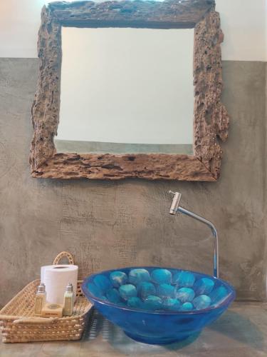 a blue bowl on a table with a mirror at Prédio em praça pontal de Maceió in Fortim