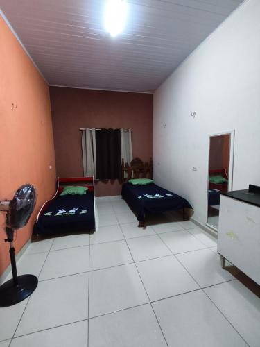 a room with two beds and a tv in it at Casa Refúgio na Serra, Tianguá in Tianguá