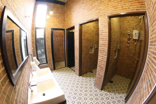 a brick bathroom with a sink and a mirror at JQ Ban Loong Boutique Hotel in Ipoh