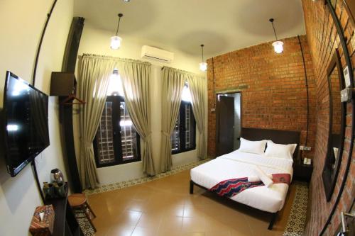 a bedroom with a bed and a brick wall at JQ Ban Loong Boutique Hotel in Ipoh