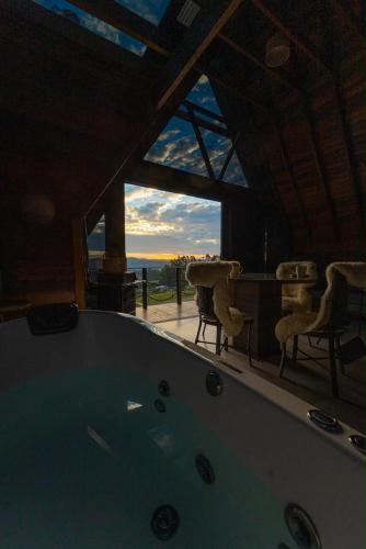 a large tub in a room with a view of the ocean at Caramelo Chalé in Rio do Sul