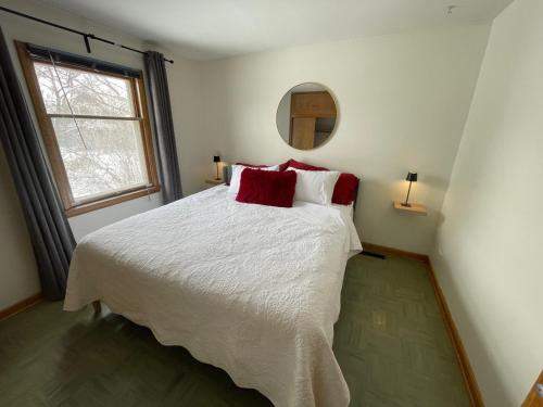 a bedroom with a large white bed with red pillows at Merlot House in Calgary
