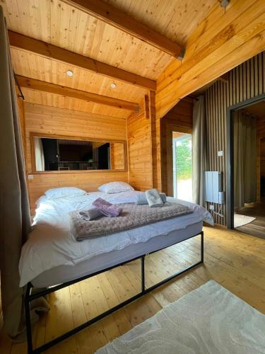 a bedroom with a large bed in a wooden cabin at Petit Chalet Cosy - Saint-Dié-des-Vosges T2 in Saint-Léonard