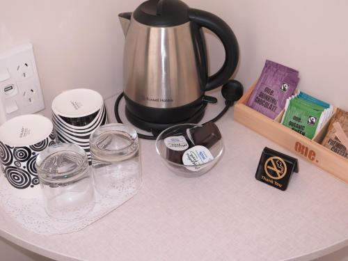 a coffee pot on a counter with plates and glasses at Wheels and Reels Accommodation in Mossburn