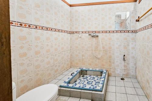 a bathroom with a toilet and a tub in it at RedDoorz at Derawan Beach Cottage in Derawan Islands